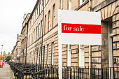 Real estate sign outside a traditional terraced house on sale