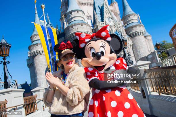 In this handout photo provided by Walt Disney Resorts, actress Drew Barrymore strikes a pose with Minnie Mouse while vacationing with family at Magic...