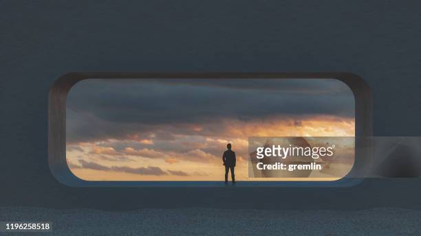 einsamer junger mann schaut durch betonfenster - abstract clouds stock-fotos und bilder