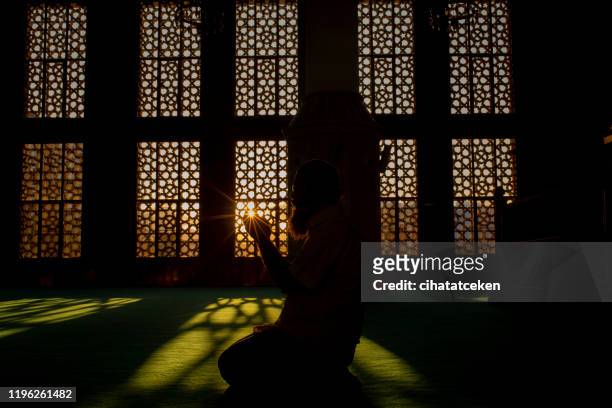 silhouette of a man worshiping in mosque - islam stock pictures, royalty-free photos & images