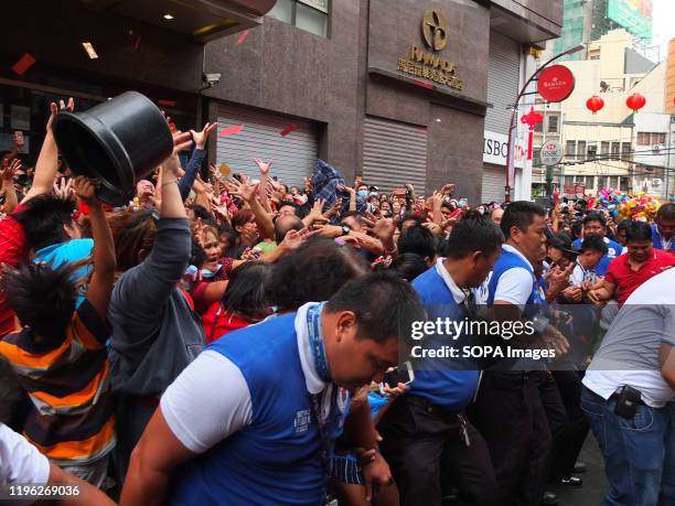 People jostling for position, because of the red envelopes falling down during the New year celebration. Filipinos and Filipino-Chinese celebrate...