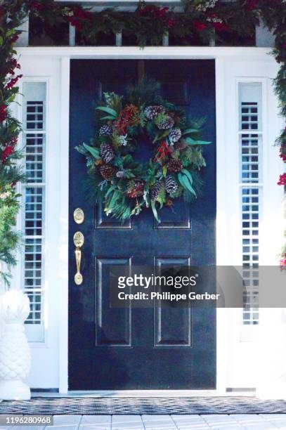 front door decorated for christmas - blue house red door stock pictures, royalty-free photos & images