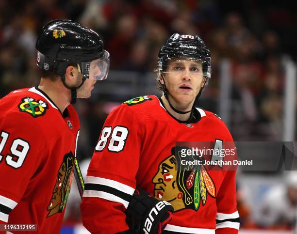Jonathan Toews of the Chicago Blackhawks talks with Patrick Kane before a face-off against the New York Islanders at the United Center on December...