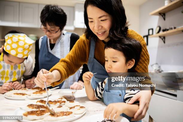 mother finishing food and son eating snacks - 日本食 個照片及圖片檔