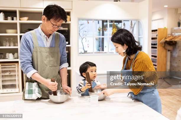 a family who participates in a cooking class with all three generations - children cooking school stock-fotos und bilder