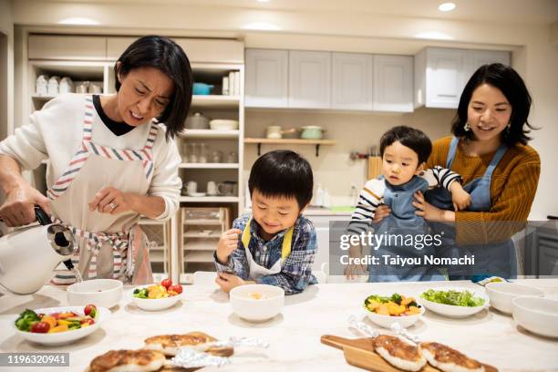 cooking class participants working together for three generations - children cooking school stock-fotos und bilder