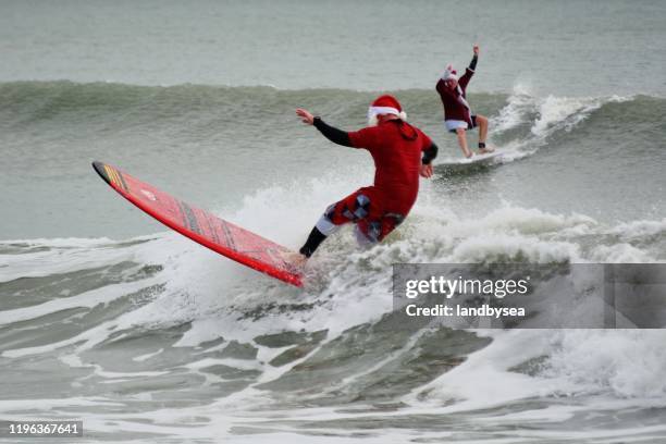 surfing santas - surfing santa stock pictures, royalty-free photos & images