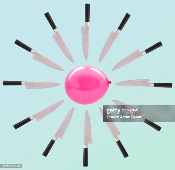 sharp knives surrounding helium balloon. - stress resistant stockfoto's en -beelden