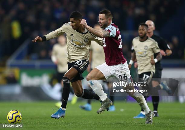 Marcus Rashford of Manchester United holds off a challenge by Phil Bardsley of Burnley FC during the Premier League match between Burnley FC and...
