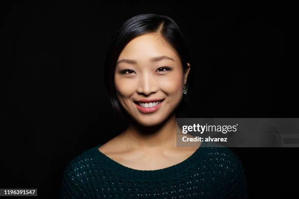 portret van aziatische vrouw op zoek naar vertrouwen - zwarte achtergrond stockfoto's en -beelden