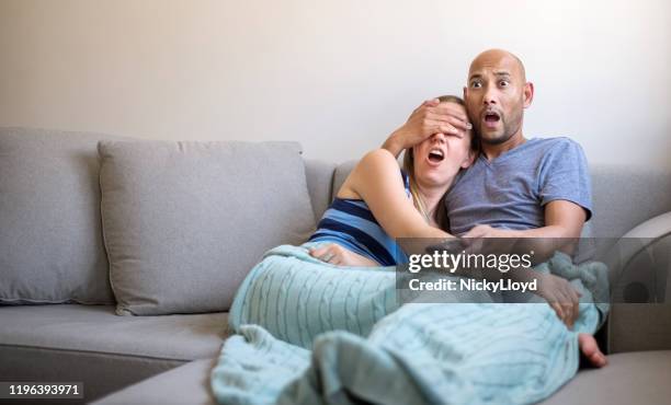 this is too tense! - woman watching horror movie stock pictures, royalty-free photos & images