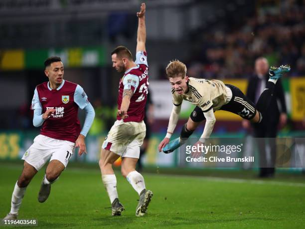Brandon Williams of Manchester United is tackled by Phil Bardsley and Dwight McNeil of Burnley FC during the Premier League match between Burnley FC...