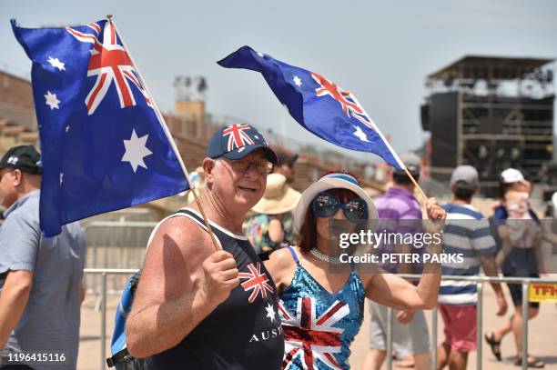 People wave the country's flag to celebrate Australia Day in Sydney on January 26, 2020.