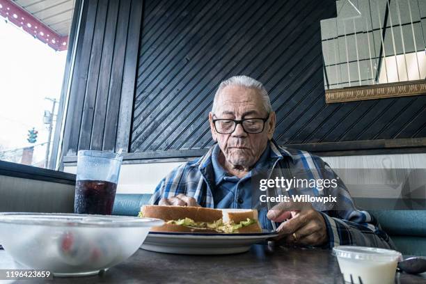 elderly man in restaurant chewing egg salad sandwich - eating egg salad sandwich stock pictures, royalty-free photos & images