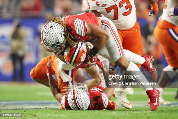 Trevor Lawrence of the Clemson Tigers is hit by Shaun Wade and Chase Young of the Ohio State Buckeyes in the first half during the College Football...