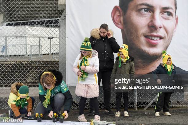 People and children lay flowers as they pay hommage to Nantes' Argentinian forward Emilianio Sala, who died one year ago in a plane crash, ahead of...