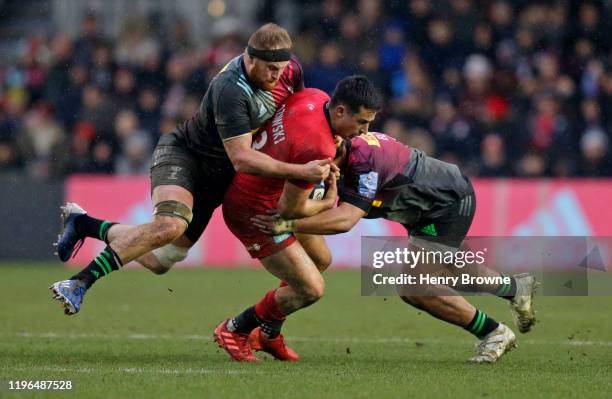 Alex Lozowski of Saracens is tackled by James Chisholm and Elia Elia of Harlequins during the Gallagher Premiership Rugby match between Harlequins...