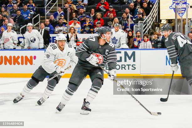 Edmonton Oilers forward Connor McDavid skates with the puck as Boston Bruins forward David Pastrnak defends and Vancouver Canucks forward Elias...