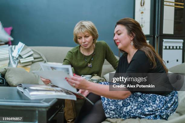 two businesswomen, 30 years old and 50 years old, discussing some project in the modern freestyle office - woman 30 years old portrait stock pictures, royalty-free photos & images