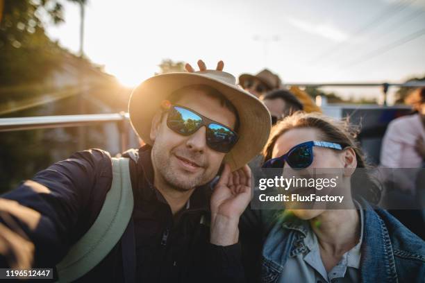 tourists exploring city on a tour bus and taking selfie - open top bus stock pictures, royalty-free photos & images