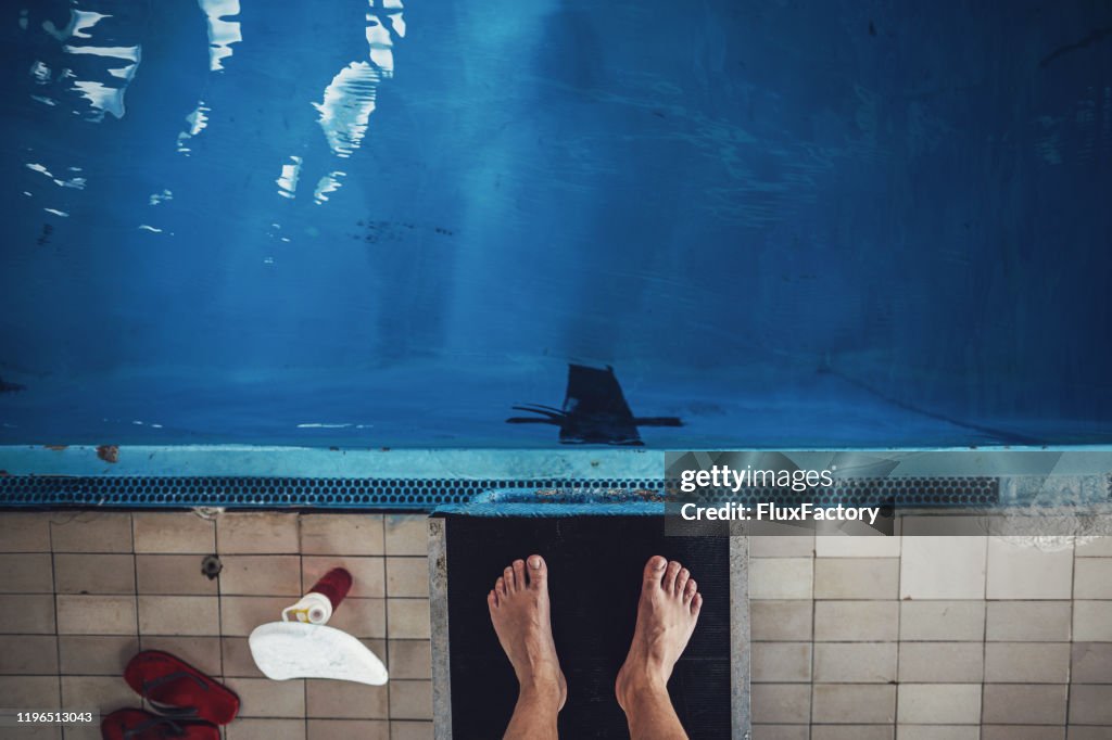 Mature swimmer standing on a diving board