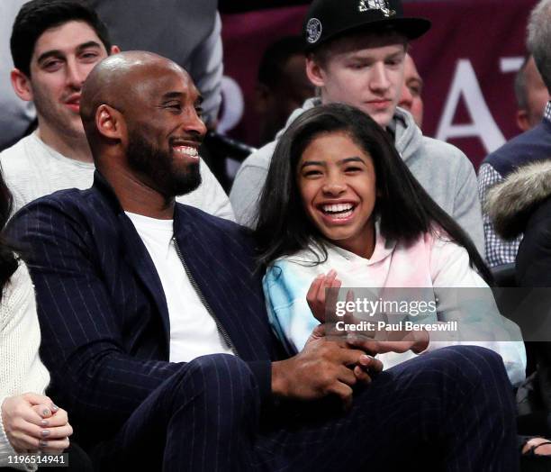 Retired NBA star Kobe Bryant and his daughter Gigi, watch an NBA basketball game between the Brooklyn Nets and Atlanta Hawks on December 21, 2019 at...