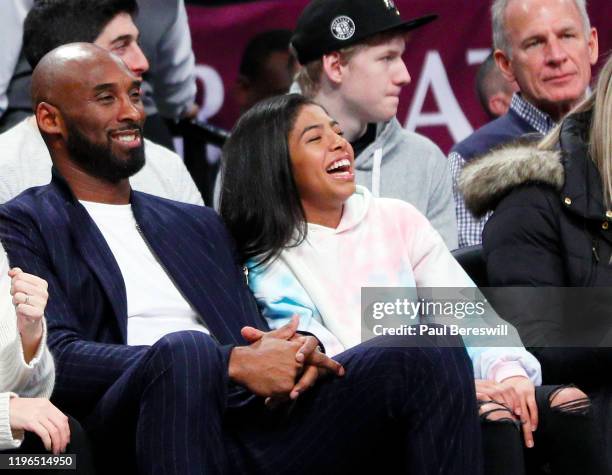 Retired NBA star Kobe Bryant and his daughter Gigi, watch an NBA basketball game between the Brooklyn Nets and Atlanta Hawks on December 21, 2019 at...