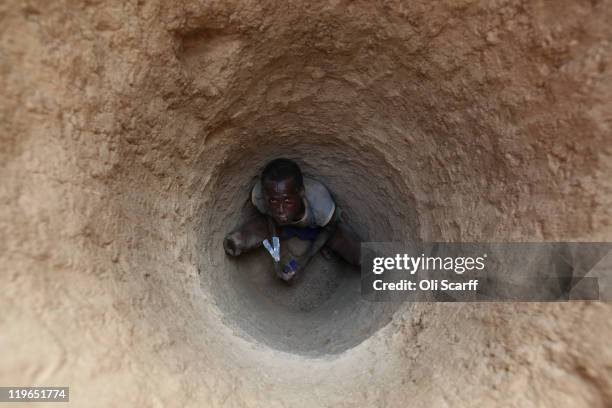 Somalian refugee digs a latrine on the outskirts of the IFO refugee camp which makes up part of the giant Dadaab refugee settlement on July 23, 2011...