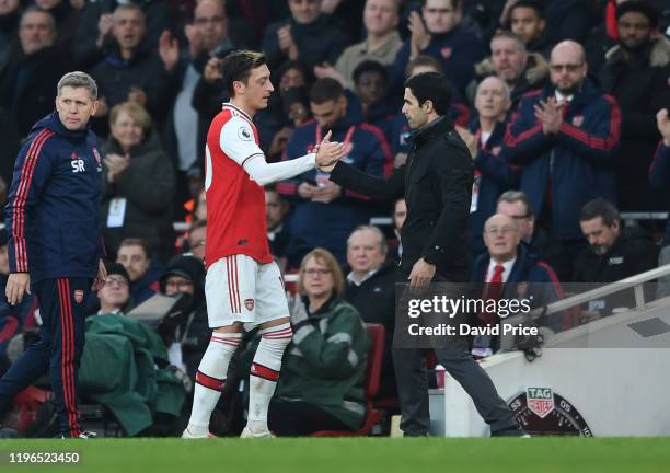 Mesut Ozil of Arsenal shakes hands with Arsenal Head Coach Mikel Arteta during the Premier League match between Arsenal FC and Chelsea FC at Emirates...