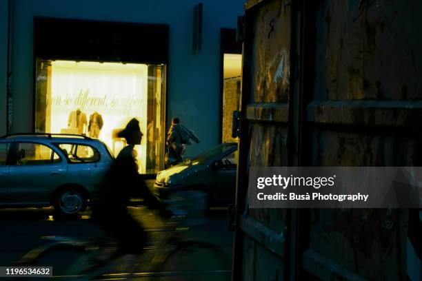 silhouette of young woman riding bike in the streets of berlin at twilight. berlin, germany - opening night of peter pan at the pantages theatre arrivals stockfoto's en -beelden