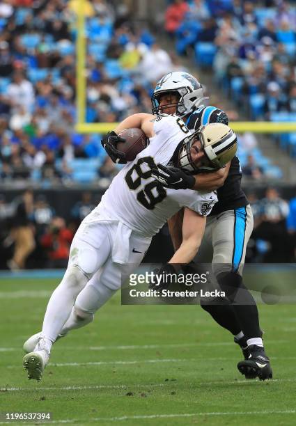 Eric Reid of the Carolina Panthers tackles Josh Hill of the New Orleans Saints during their game at Bank of America Stadium on December 29, 2019 in...