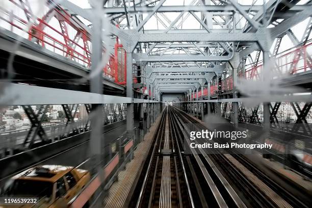 view of railroad tracks on the manhattan bridge from rear window of subway car in new york city - mezzanine stockfoto's en -beelden