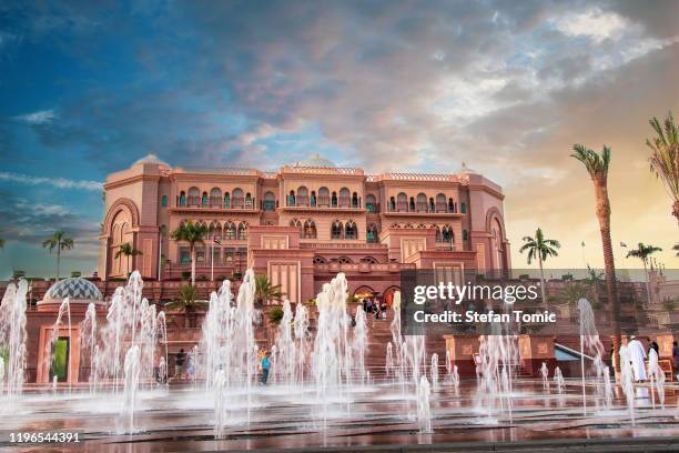 emirates palace in abu dhabi reflected on the ground level fountain - emirates palace stock pictures, royalty-free photos & images