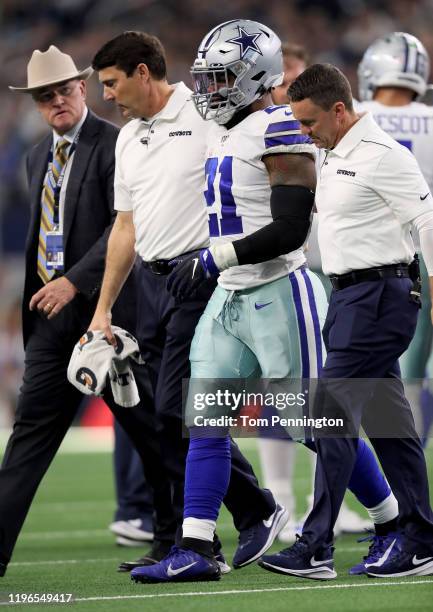 Ezekiel Elliott of the Dallas Cowboys is helped off the field after being injured in the first quarter against the Washington Redskins in the game at...