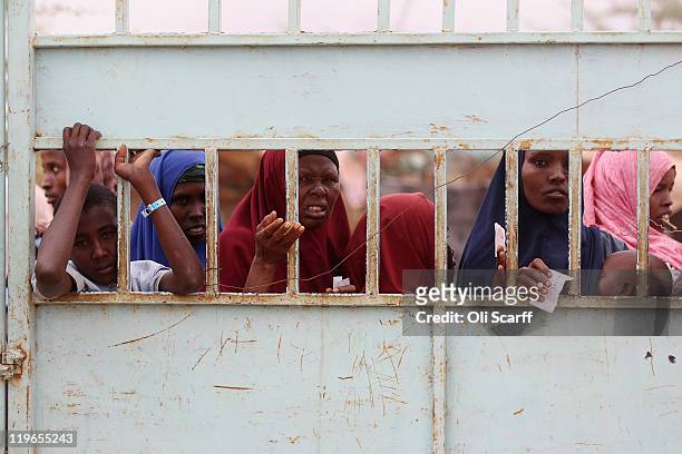 Somalian refugees wait at the entrance to the registration area of the IFO refugee camp which makes up part of the giant Dadaab refugee settlement on...