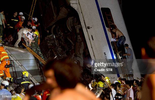 Chinese rescue workers tend to the victims of a high-speed train accident on July 23 near Wenzhou. Two train cars derailed and fell off a bridge...