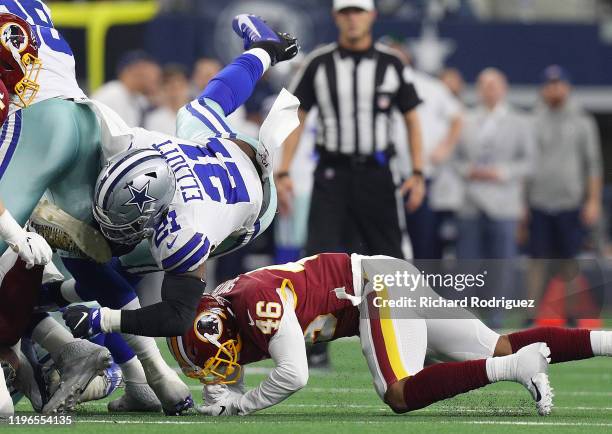 Ezekiel Elliott of the Dallas Cowboys goes down after being hit by Maurice Smith of the Washington Redskins in the first quarter at AT&T Stadium on...