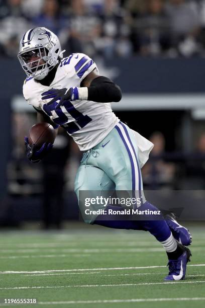 Ezekiel Elliott of the Dallas Cowboys runs with the ball in the second quarter against the Washington Redskins in the game at AT&T Stadium on...