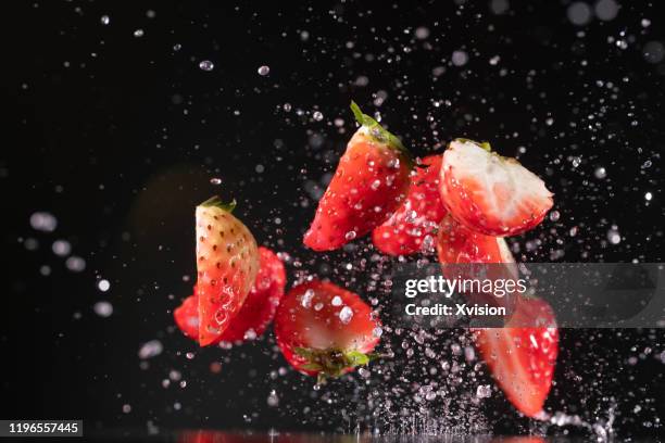 strawberry flying in mid air captured with high speed sync. - zeitlupe stock-fotos und bilder
