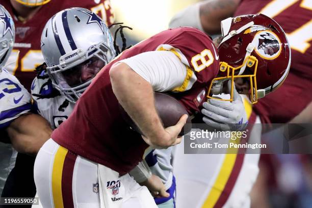 Jaylon Smith of the Dallas Cowboys grabs the facemask of Case Keenum of the Washington Redskins in the second quarter in the game at AT&T Stadium on...