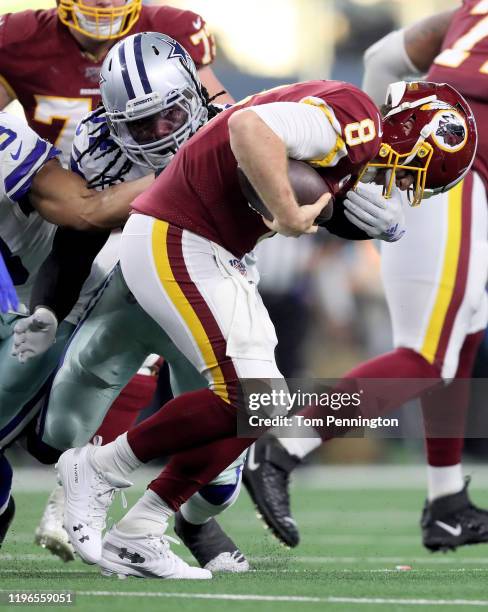 Jaylon Smith of the Dallas Cowboys grabs the facemask of Case Keenum of the Washington Redskins in the second quarter in the game at AT&T Stadium on...