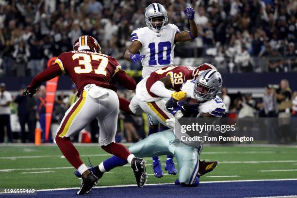 Ezekiel Elliott of the Dallas Cowboys scores a touchdown past Coty Sensabaugh and Jeremy Reaves of the Washington Redskins in the second quarter in...