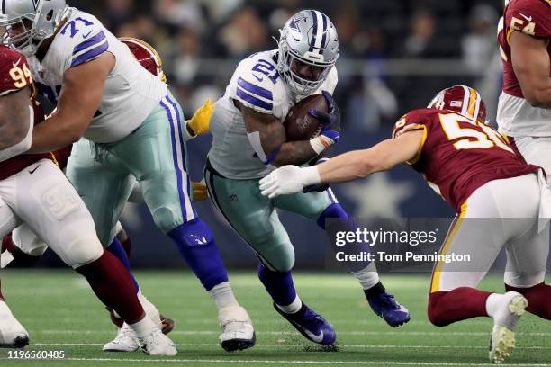 Ezekiel Elliott of the Dallas Cowboys runs with the ball while being chased by Cole Holcomb of the Washington Redskins in the second quarter in the...