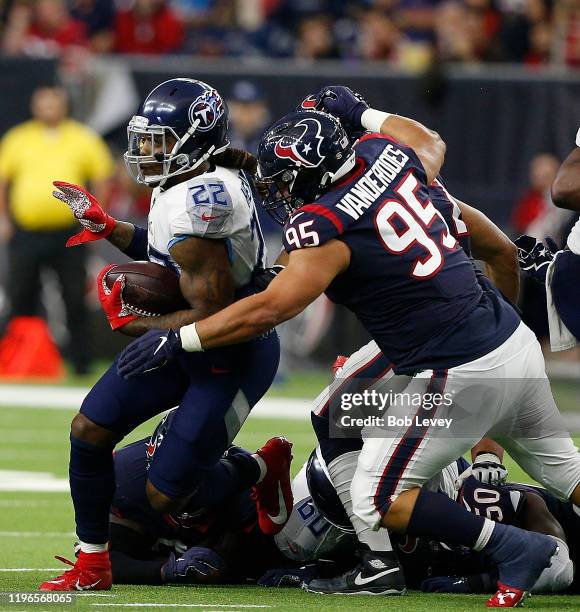 Derrick Henry of the Tennessee Titans is tackled by Eddie Vanderdoes of the Houston Texans during the fourth quarter at NRG Stadium on December 29,...