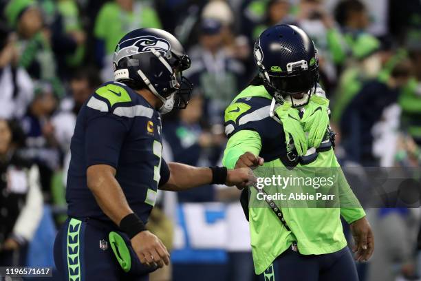 Quarterback Russell Wilson of the Seattle Seahawks fist bumps running back Marshawn Lynch before taking on the San Francisco 49ers during the game at...