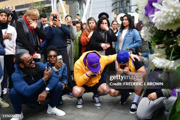 People gather around a makeshift memorial for former NBA and Los Angeles Lakers player Kobe Bryant after learning of his death at LA Live plaza in...