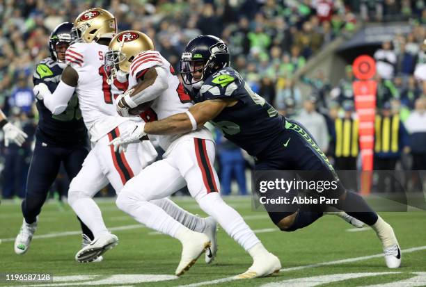 Running back Tevin Coleman of the San Francisco 49ers is tackled by linebacker Mychal Kendricks of the Seattle Seahawks during the first quarter of...