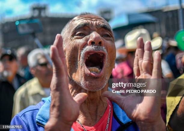 Supporter of Mexican President Andres Manuel Lopez Obrador shouts slogans at people participating in a march for peace in Mexico City, on January 26,...