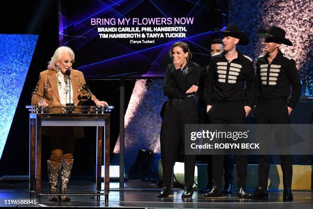 Singer-songwriter Brandi Carlile stands onstage as US musician Tanya Tucker accepts the award for Best Country Song for "Bring My Flowers Now" during...