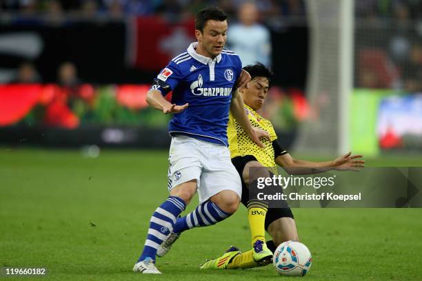 Shinji Kagawa of Dortmund challenchallenges Alexander Baumjohann of Schalke during the Supercup match between FC Schalke 04 and Borussia Dortmund at...